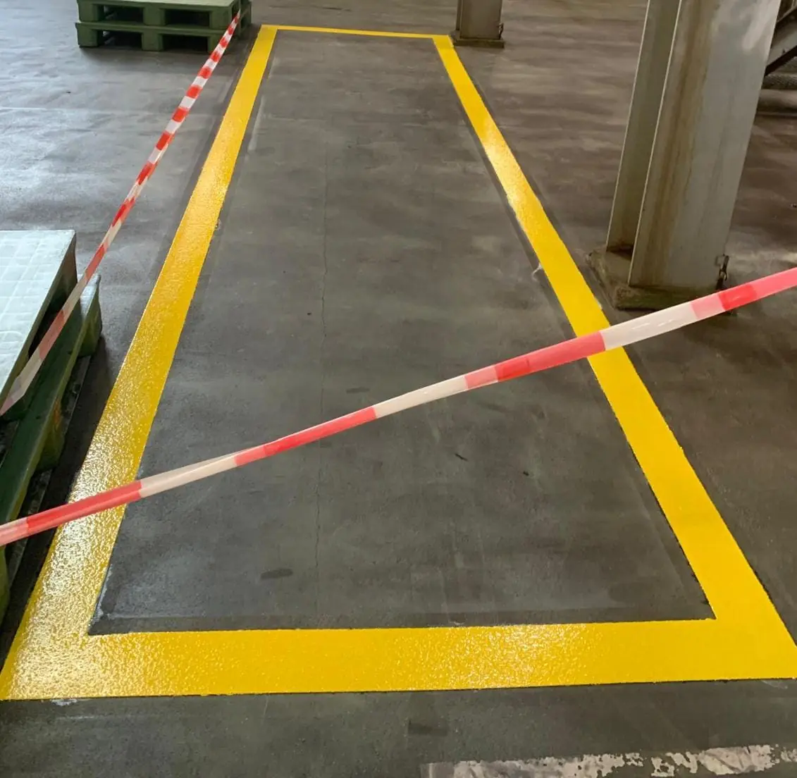 Gelb markierter Gehweg auf einer Lagerfläche